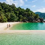 Secluded private beach on Pangkor Laut island surrounded by tropical jungle