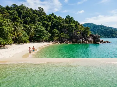 Secluded private beach on Pangkor Laut island surrounded by tropical jungle